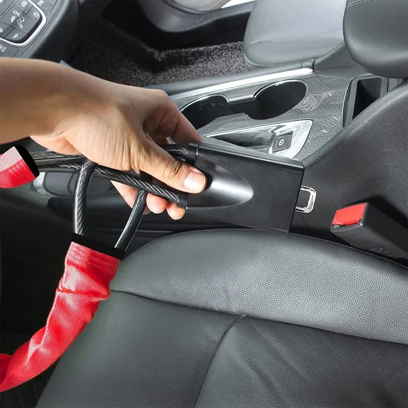 A hand is operating a universal steering wheel and seatbelt lock mechanism inside a car interior.
