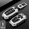 Silver universal car key fob cover with four buttons shown on a dark background.