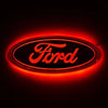 A glowing red oval logo featuring the word Ford in script on a dark background.