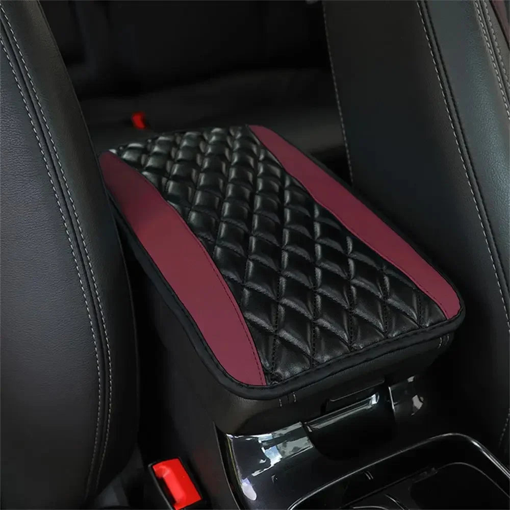 A black quilted armrest protector pad with a maroon accent is shown inside a car interior.