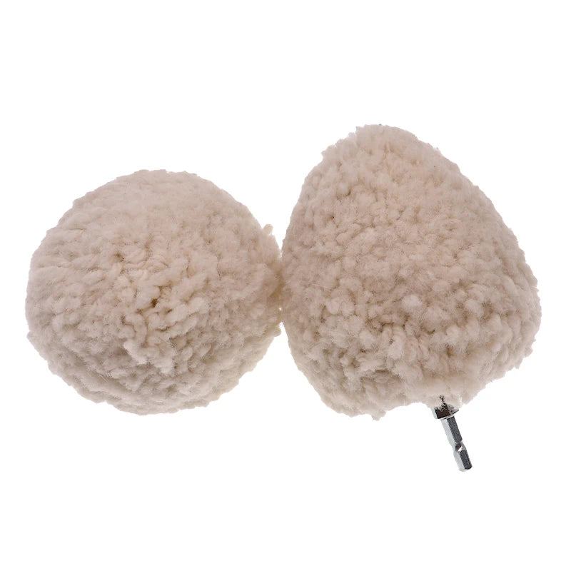 Zwei flauschige, hellbeige Wollpolierbälle mit Metallstielen.