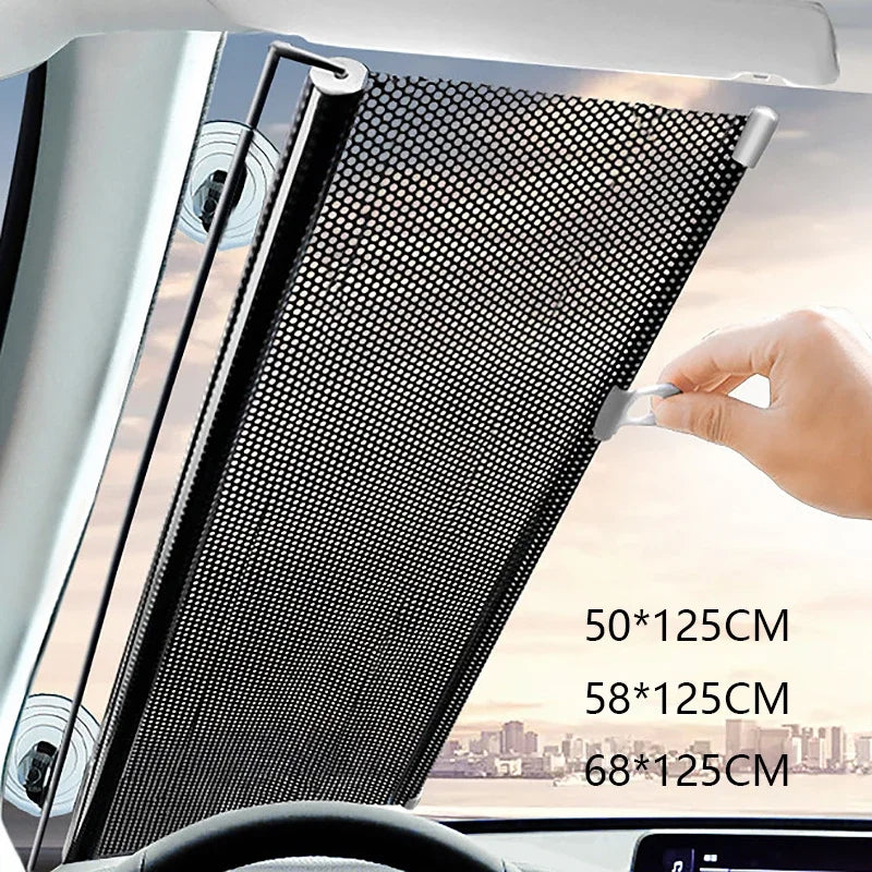 A hand is adjusting a black mesh retractable car windshield sun shade in a vehicle interior.