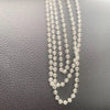 A delicate gold-toned chain necklace featuring small clear crystal beads and a pink lotus car pendant ornament.