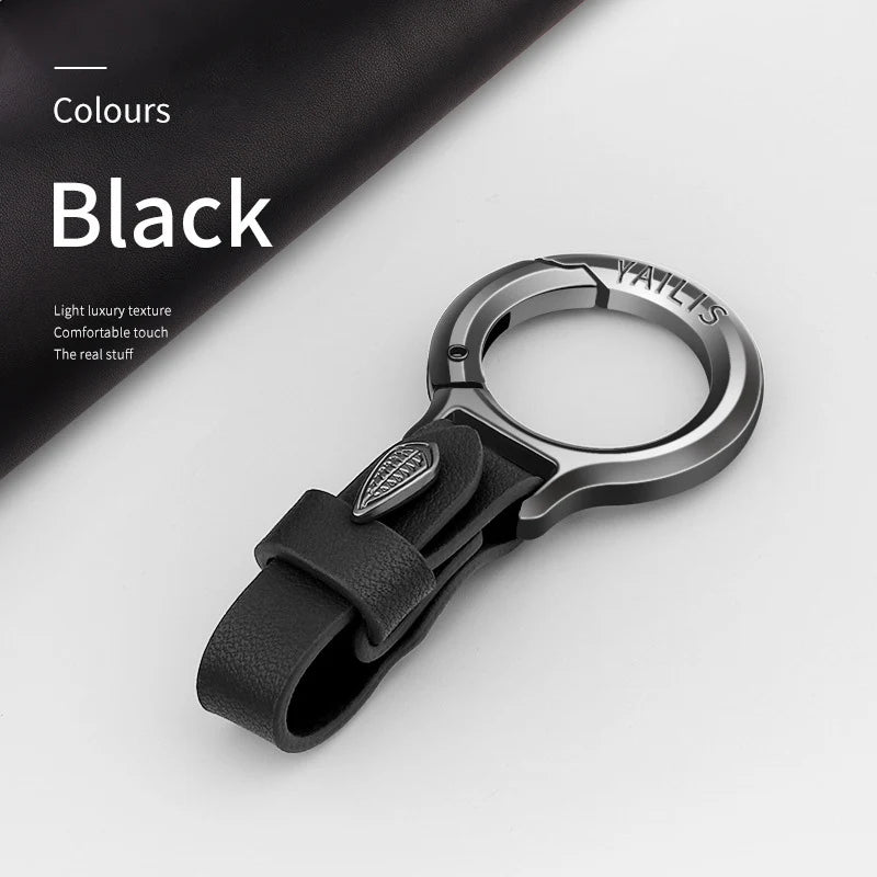 A black Yaelts leather keychain with a silver ring and black strap is shown on a white background.