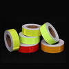 Rollos de cinta de advertencia de PVC reflectante en colores amarillo, verde lima y naranja.