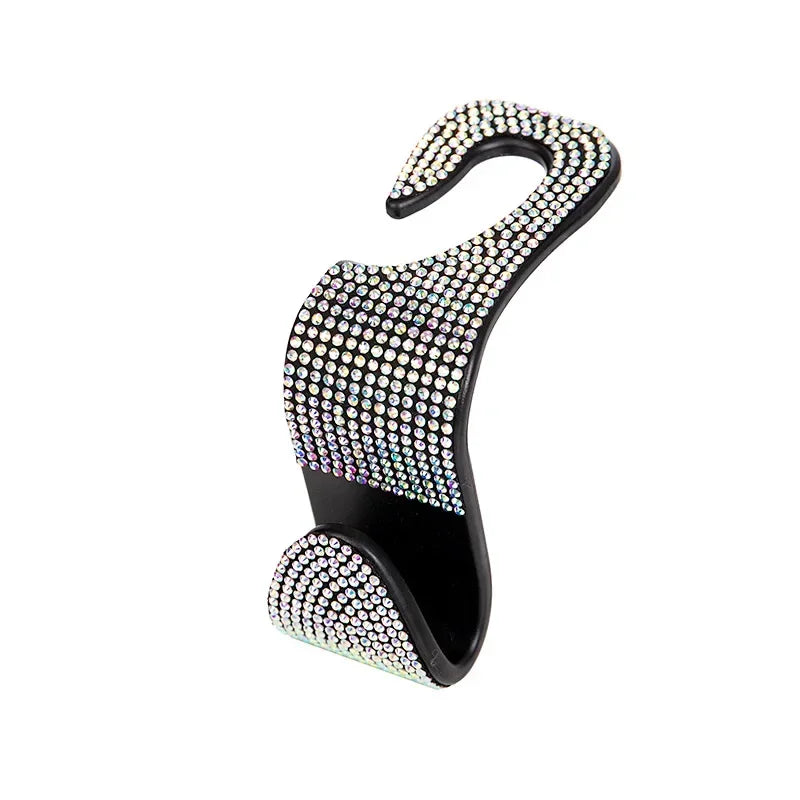 A black car seat back headrest with storage hooks covered in sparkling rhinestones.