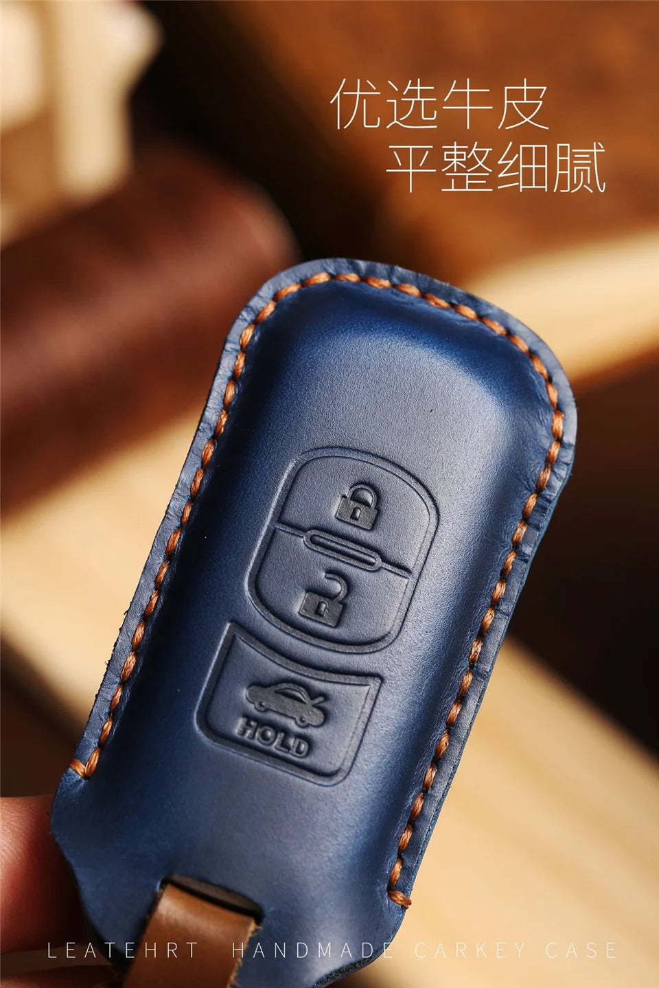 A dark blue leather handmade Carkey case with a key slot and a hold feature.