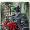 A person wearing a motorcycle helmet and leather gloves sits on a red Ducati motorcycle with a fanny pack attached to the sea
