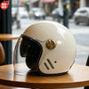 A cream-colored two-lens retro motorcycle helmet resting on a wooden table.