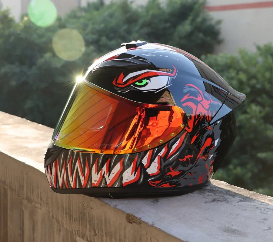 A glossy black full face motorcycle helmet with an orange visor featuring a fierce tiger eye design resting on a concrete led