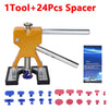 A tool kit for car dent repair featuring a gold and silver spacer tool and various plastic spacers.