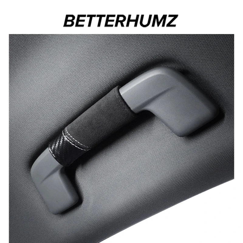 A close-up view of a gray car roof handle cover made of Alcantara material with a black grip.