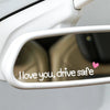 Gros plan sur le rétroviseur de voiture montrant un autocollant en vinyle cœur indiquant "I love you drive safe"