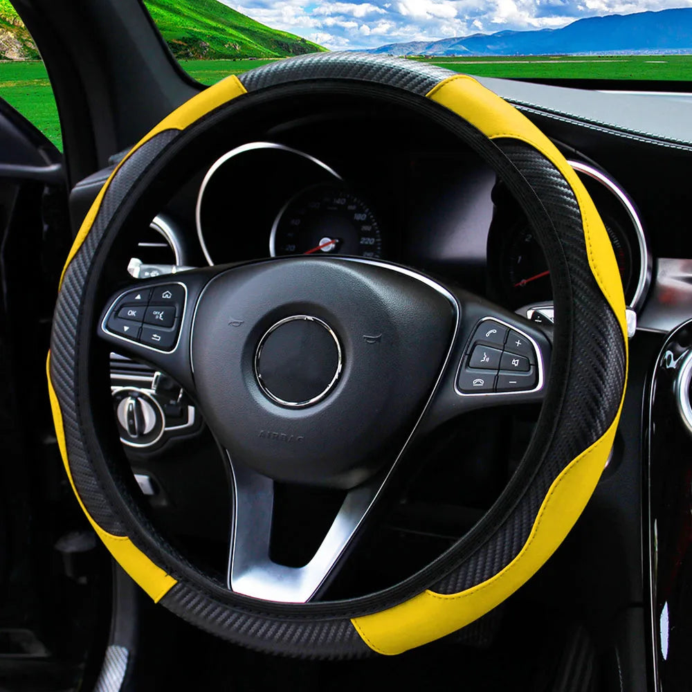 A black steering wheel with a yellow carbon fiber grip cover inside a car