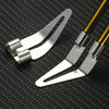 A pair of silver precision plastic welding and repair tools with gold-colored handles resting on a black textured surface.