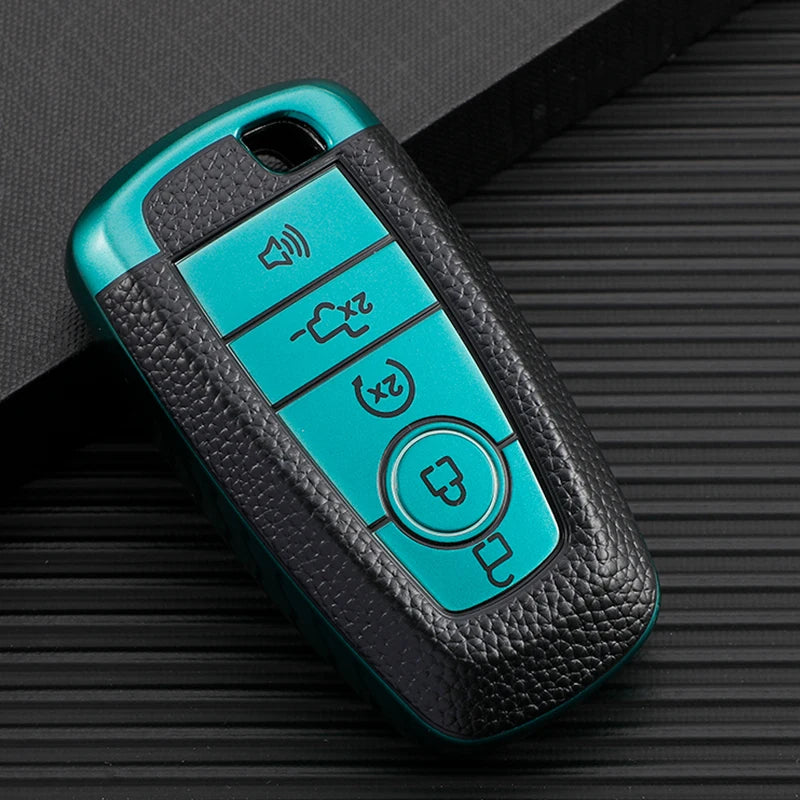 A teal and black multi-function key fob holder with various buttons resting on a dark surface.