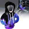 A cozy knit gear shift cover in purple and black with a hood, shown alongside an automotive shifter.