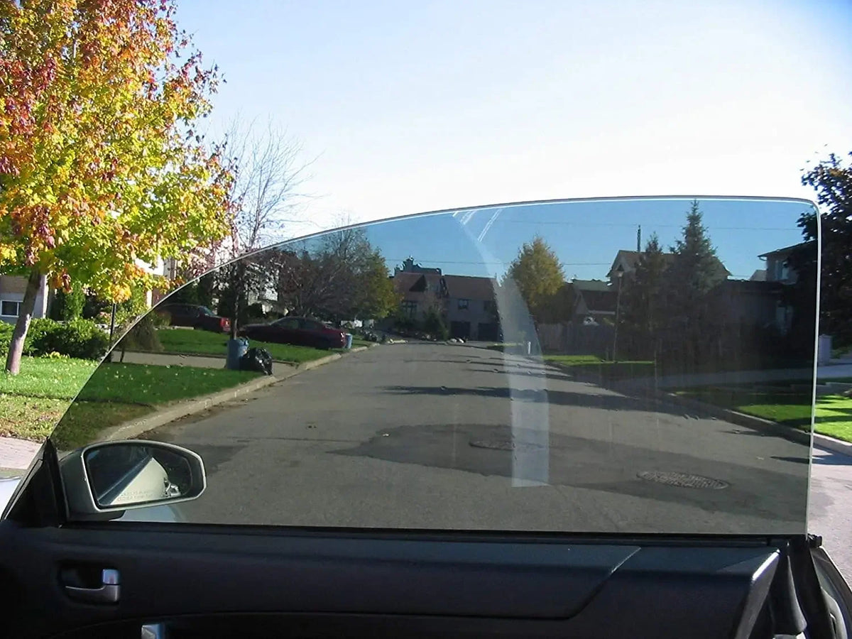 A close-up view of a car window with professional heat and UV blocking film installed.