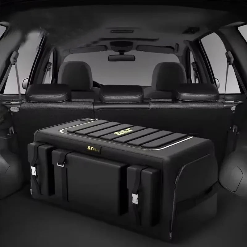 Une boîte de rangement universelle noire pour coffre de voiture, montrée dans le coffre.