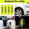 Four yellow reflective decals designed for safety applied to a white car door and wheel.