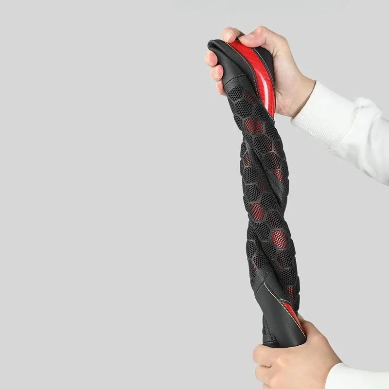يد تحمل غطاء عجلة قيادة أسود مريح مع لمسات حمراء.