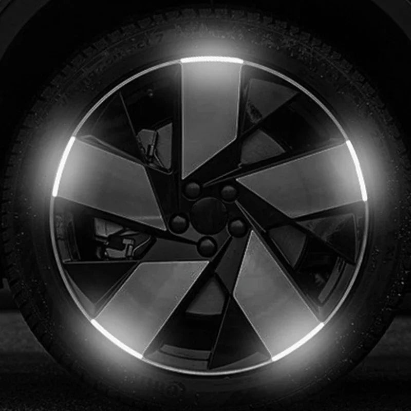 Gros plan sur une roue de voiture ou de moto noire avec un décalcomanie à multiples rayons réfléchissants.