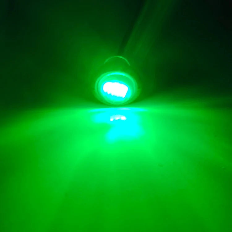 Feu de position vert vif LED éclairant un faisceau sur fond sombre.