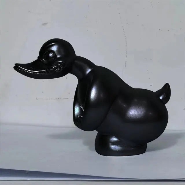 A glossy black decorative angry duck hood ornament for a car or motorcycle.
