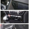 Close-up shots of a car interior featuring carbon fiber accents, including the front bumper, door panel, and steering wheel.
