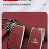 A close-up of a metallic Lexus car key cover shell in a matte red color resting on a dark red surface.