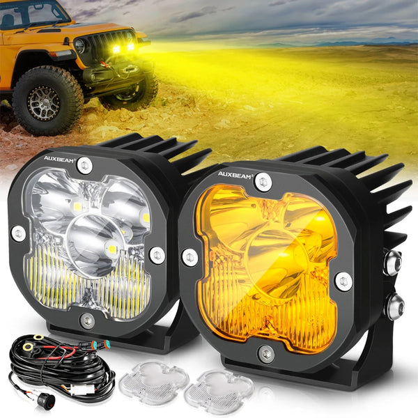 A pair of powerful yellow and amber LED off-road driving lights with wiring and lenses displayed on a surface.