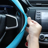 Eine Hand justiert eine leuchtend blaue Silikon-Schutzabdeckung für das Lenkrad eines Autos.