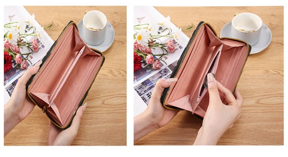 A pink leather long wallet with a black trim is shown open, next to a cup and saucer.