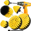 An orange handheld electric brush set with yellow and black bristles and a cleaning attachment.