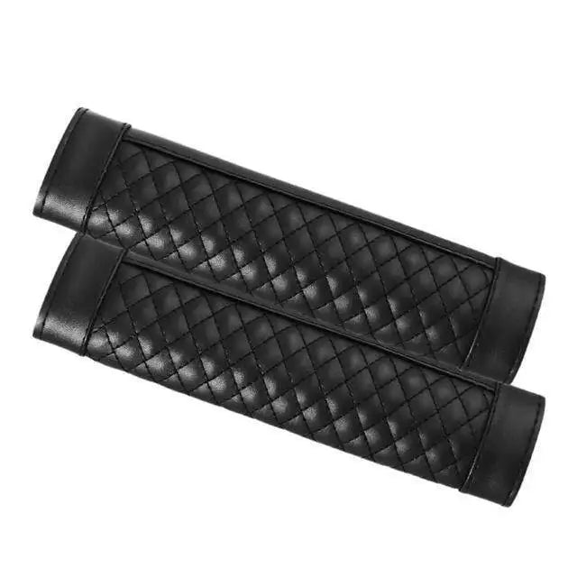 A pair of black PU leather car seat belt covers with a quilted pattern.