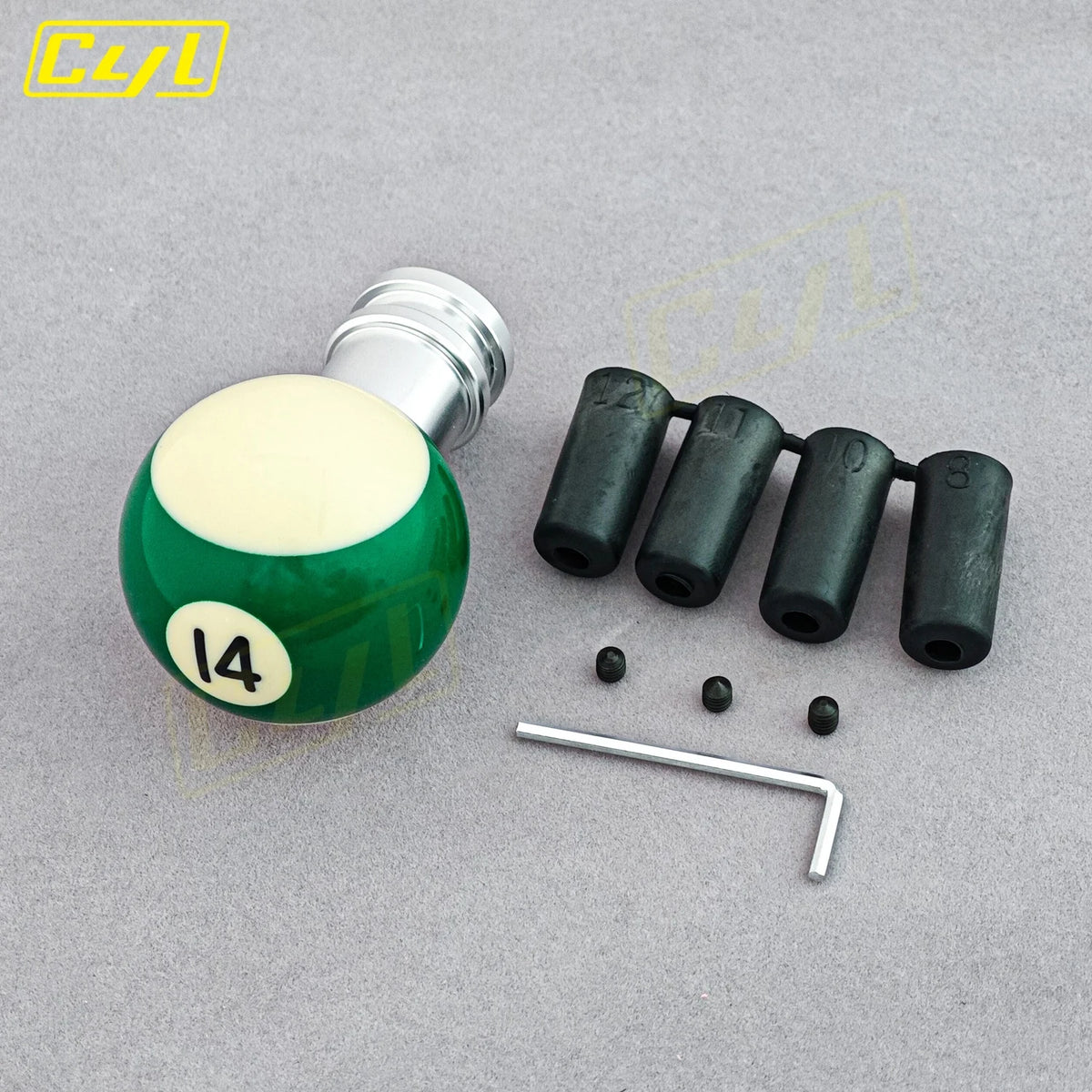 Kugelformiges Schalthebel mit grünem Grund und silbernem Deckel, sowie mehrere schwarze zylindrische Teile und ein Metallstab