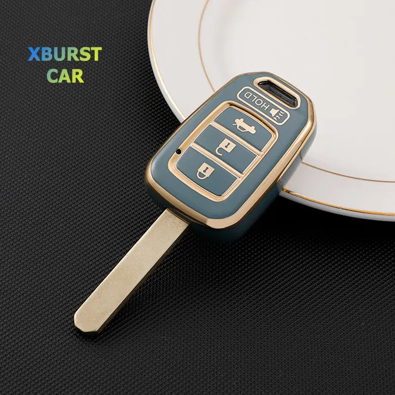 A teal TPU car key fob cover with three buttons is shown resting on a white plate.