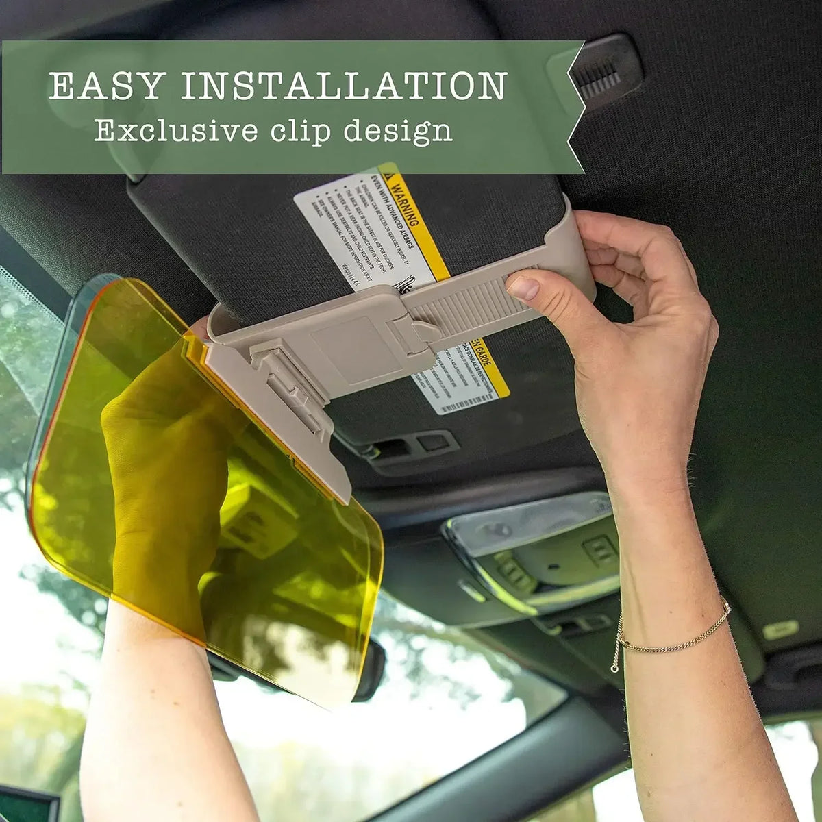 Eine Hand installiert einen klaren gelben Sonnenblende-Visor mit einem exklusiven Clipsystem im Auto-Innenraum.