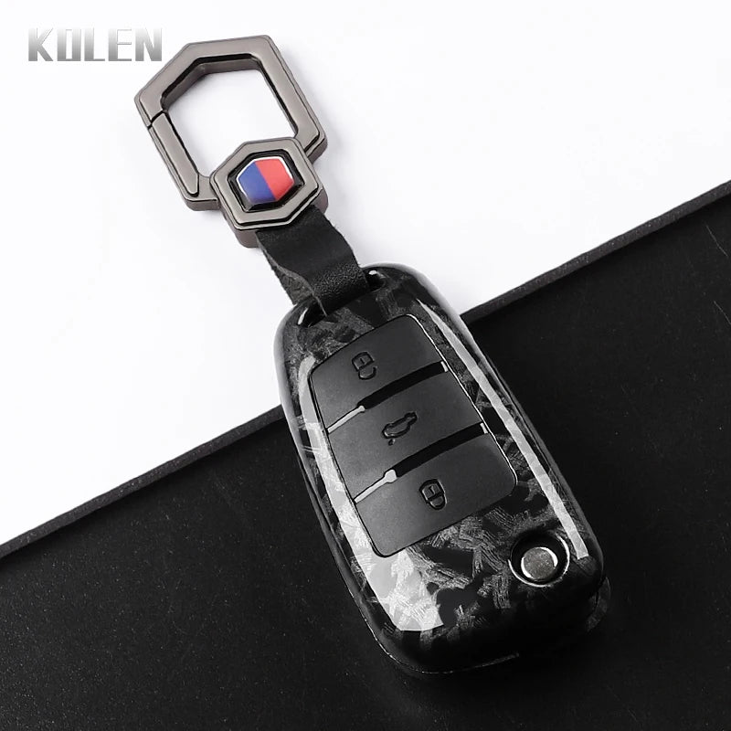 A black carbon fiber car key case cover with a silver keyring and electronic key features.
