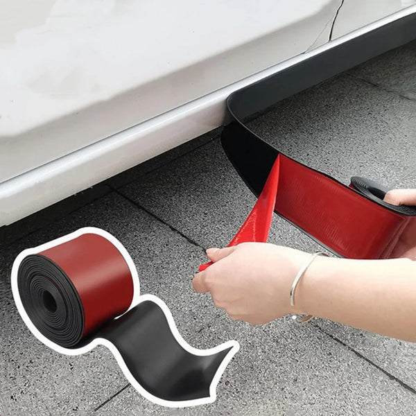 A hand is applying a self-adhesive car door protection strip, which is red and black, to the side of a white car door.