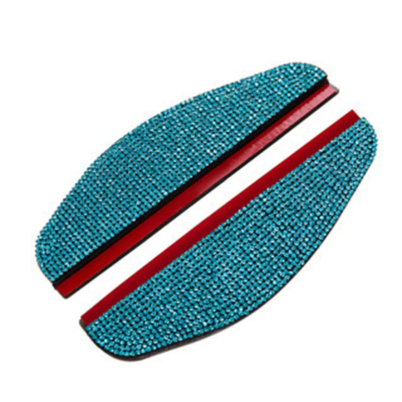 A pair of turquoise rhinestone car rain shield visors with red accents.