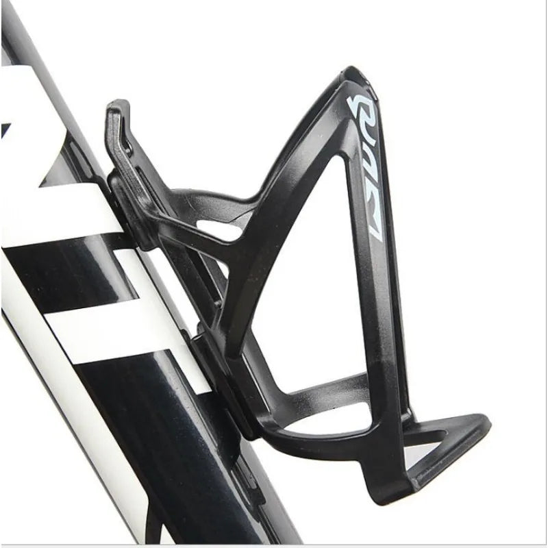 Black plastic bicycle bottle holder rack mounted on a bicycle frame.