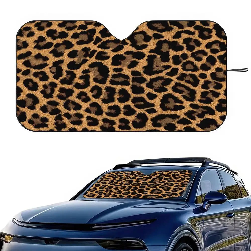 A leopard print car sunshade is shown fitted onto the windshield of a blue car.