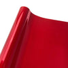 Close-up view of a glossy red vinyl car wrap film showing a curved surface.