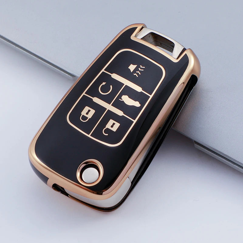 A black and gold durable TPU key fob case for Chevrolet and GMC vehicles shown on a light gray surface.