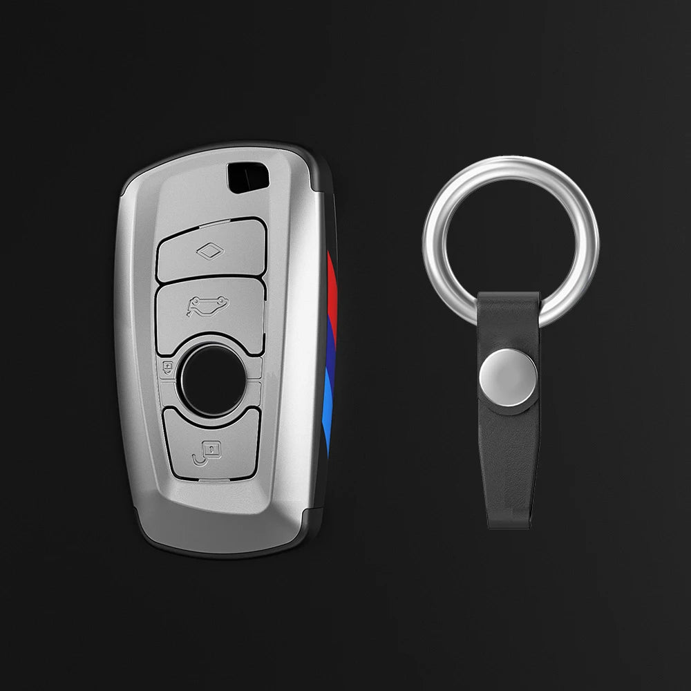 Juego de fundas para llaves de coche plateadas con llavero y cordón negro.