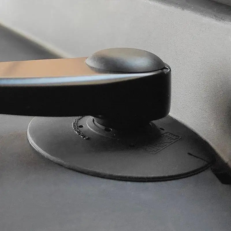 A black car windshield debris protector sleeve with a rounded top is shown resting on a dark surface.