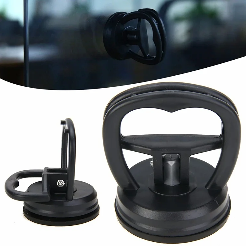 A black suction cup dent puller tool with a handle and base is shown.