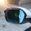 Close-up of an anti-fog textured rearview mirror cover installed on a vehicle.