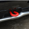Close-up of a red tow hook cover installed on a silver car exterior bumper.